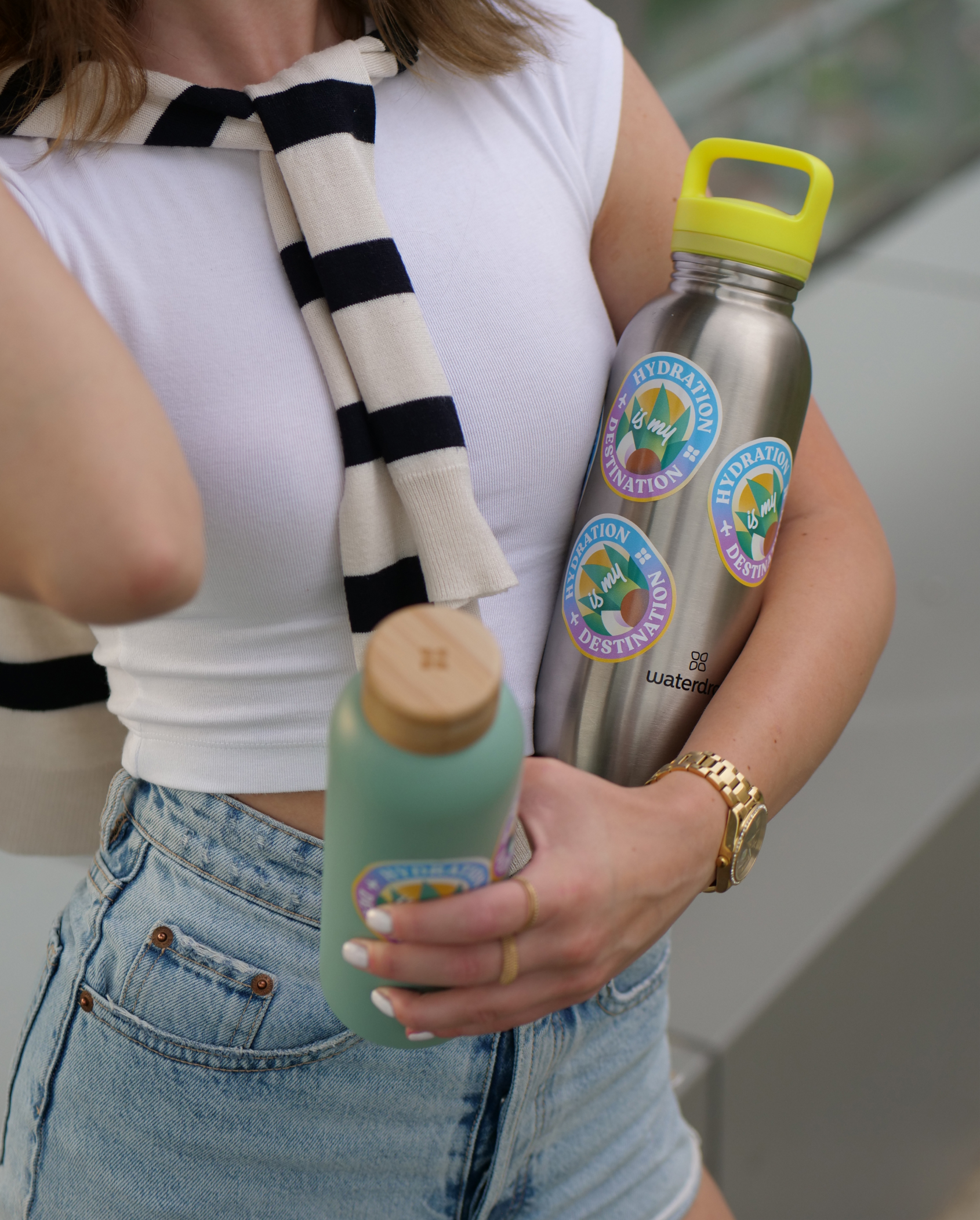 Sticker pour Bouteille held by person.