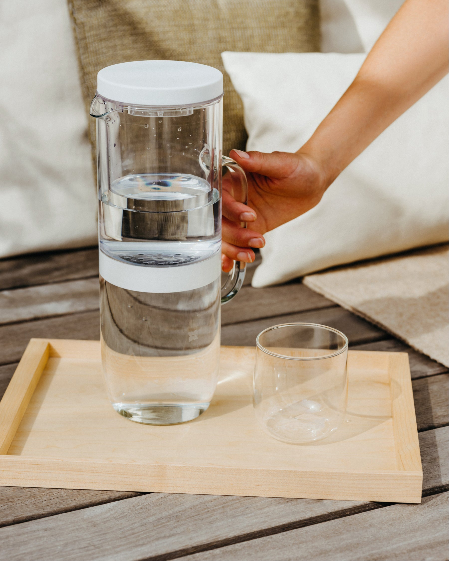 Carafe Filtrante LUCY® with glass and jug on tray.