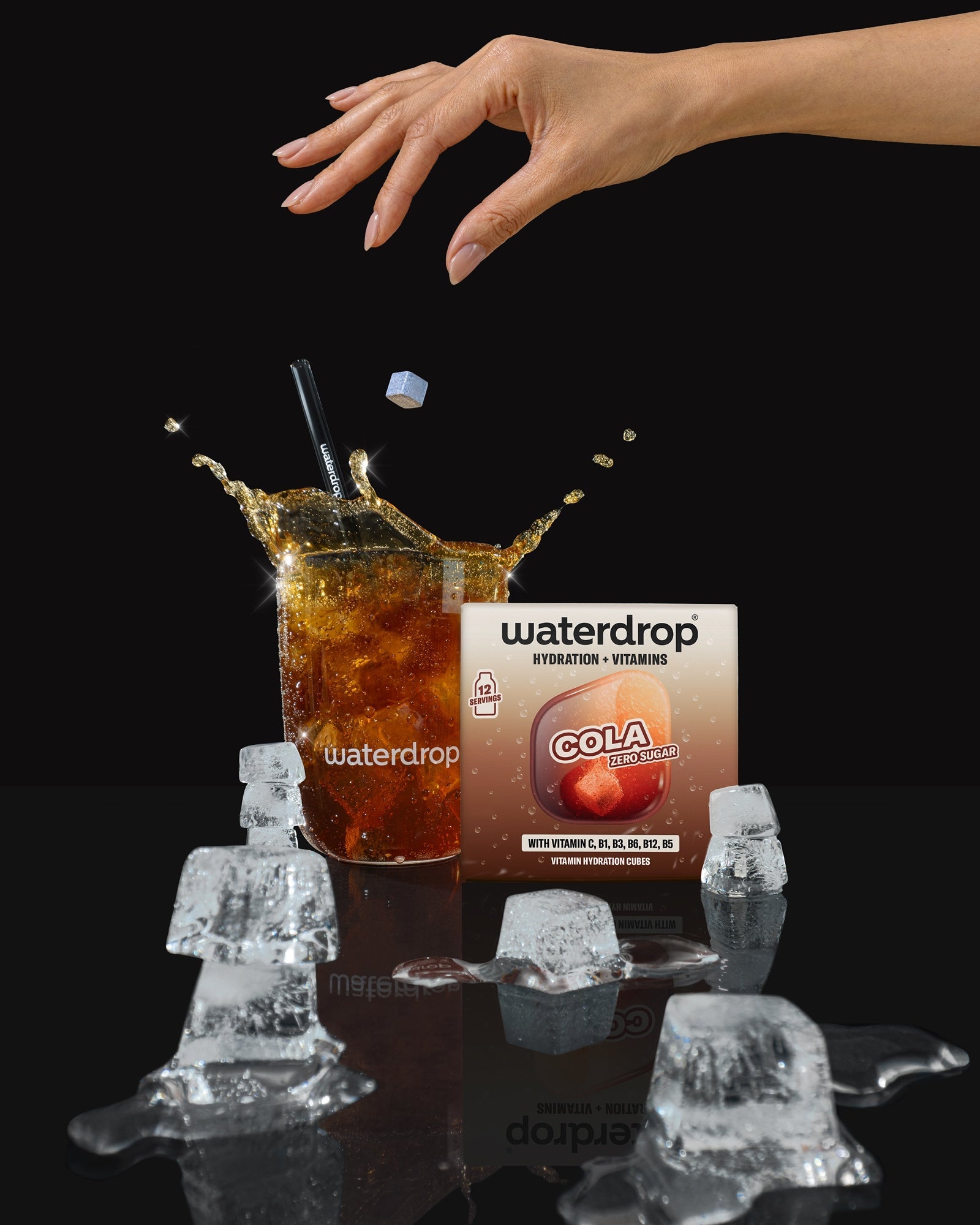 Double Pack COLA hydration cubes mid-splash in branded glass.