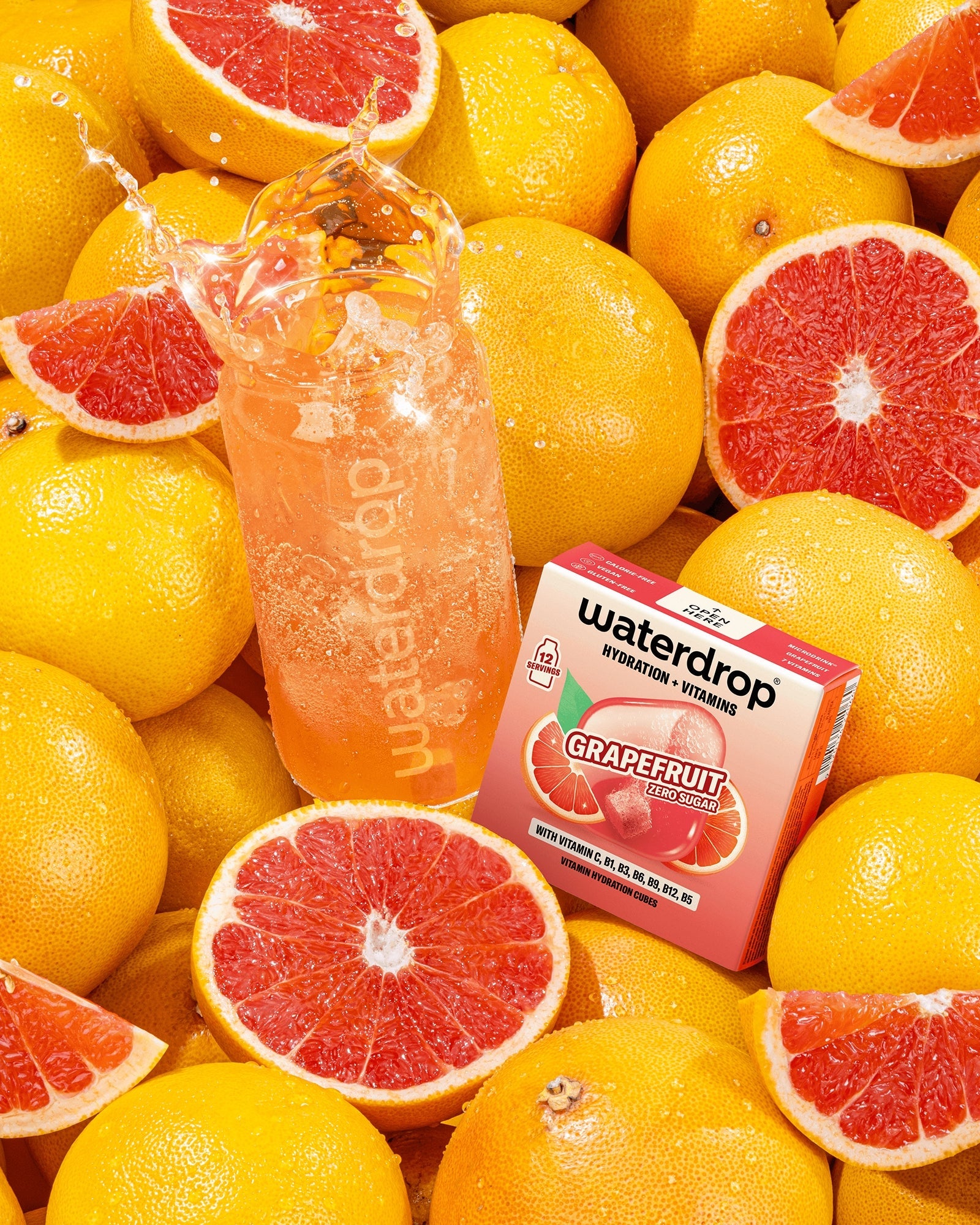 Assortiment de pamplemousses avec une bouteille de boisson rose pamplemousse et une petite boîte parmi les fruits.