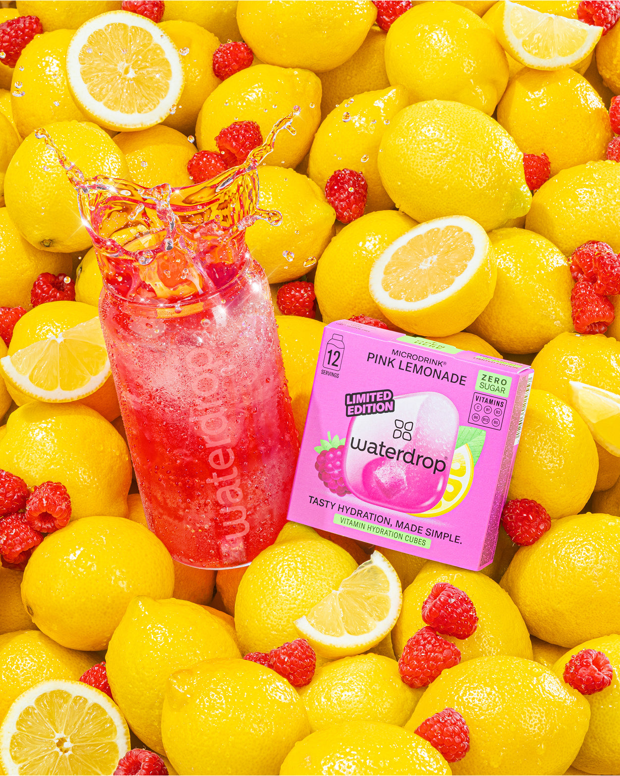 Bouteille de limonade rose et boîte Waterdrop parmi des citrons jaunes.