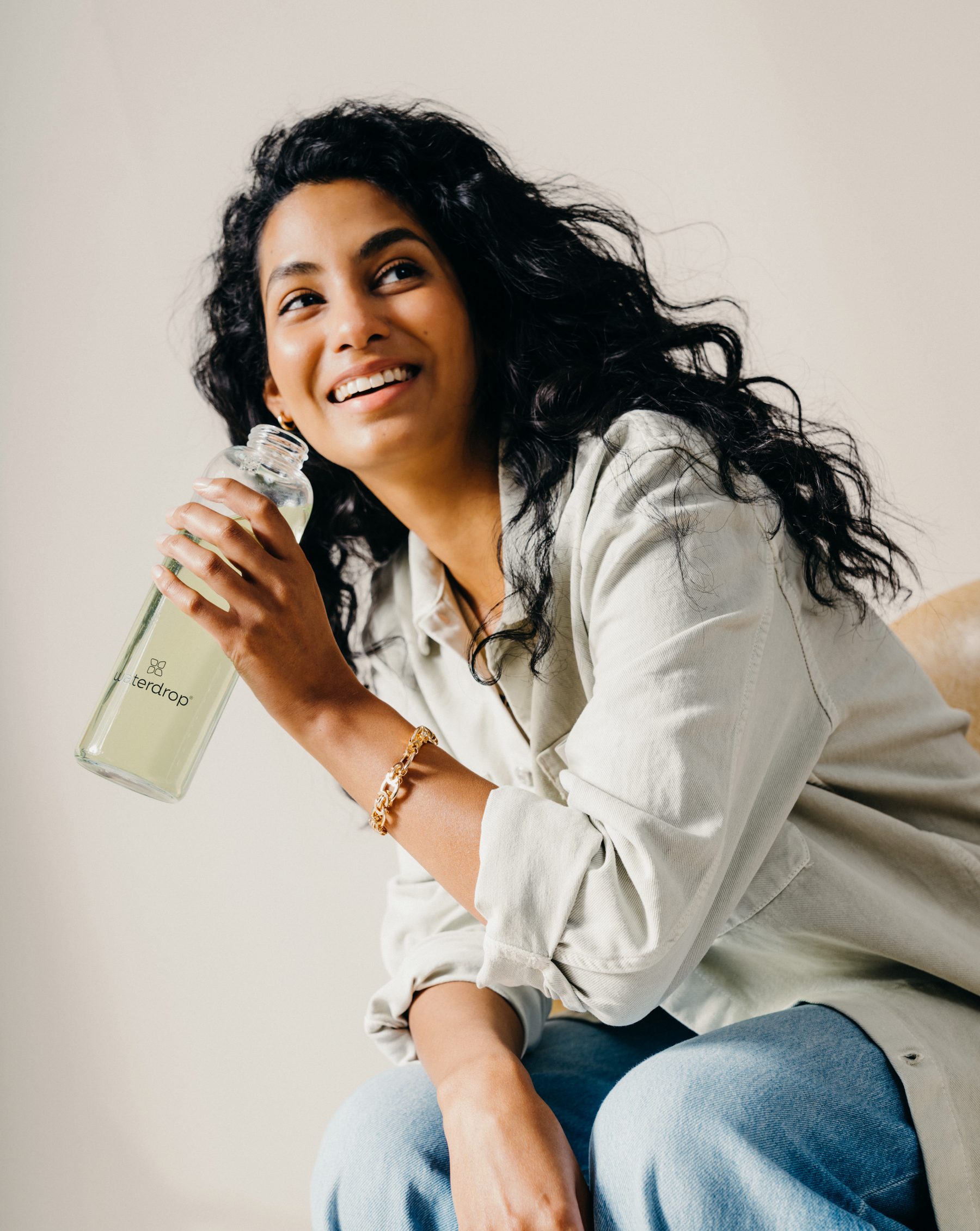 Transparente en Verre bottle held by a smiling woman.
